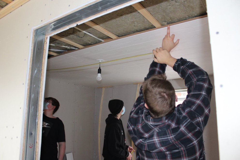 Unnið að því að festa loftaþiljur.