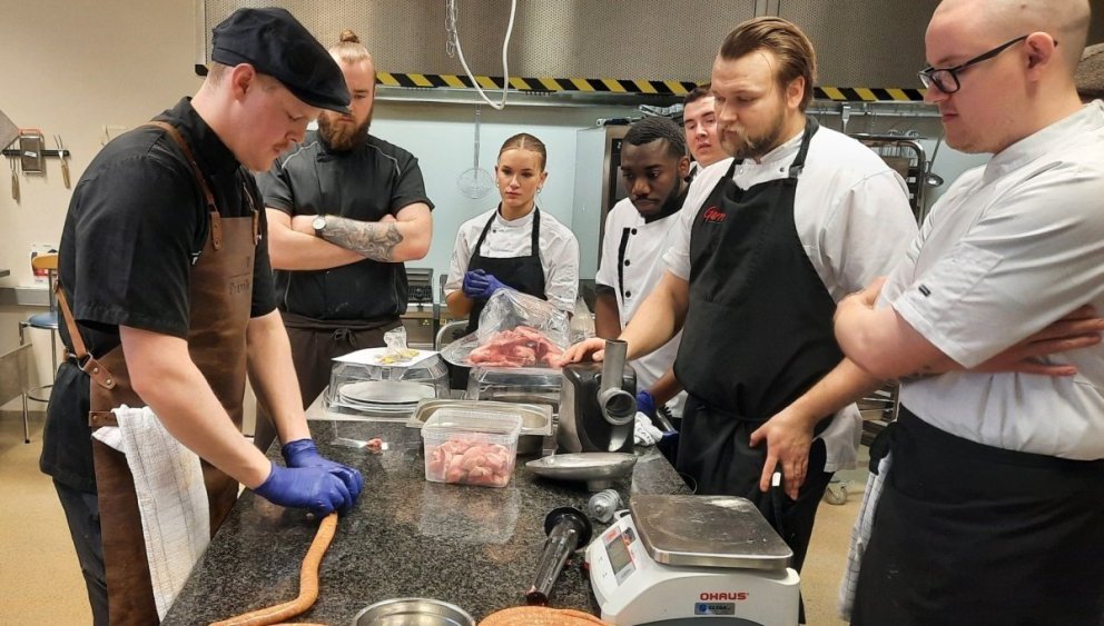 Rúnar Ingi Guðjónsson kjötiðnaðarmaður leiðbeinir nemendum í pylsugerðinni.