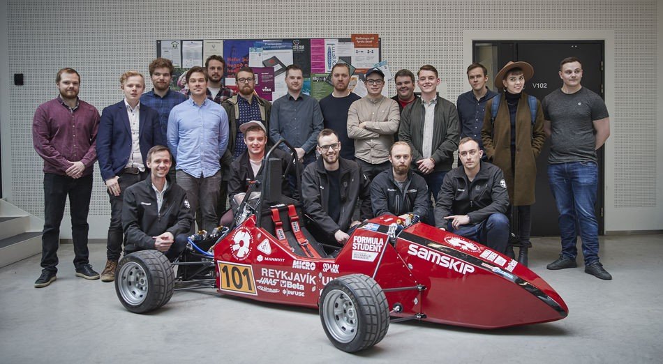 Arnór við bílinn, krjúpandi í miðju.