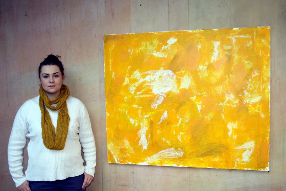 Guðrún Gísladóttir við gula málverkið sitt.