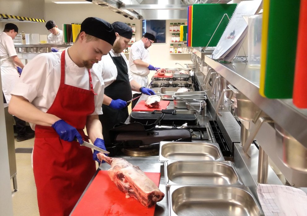 Nemendur spreyta sig á úrbeiningu lambalæra.