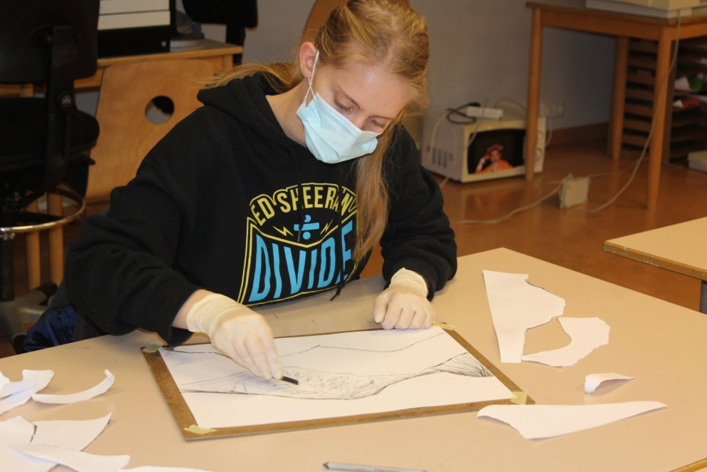 Unnið að listsköpun með kolum.