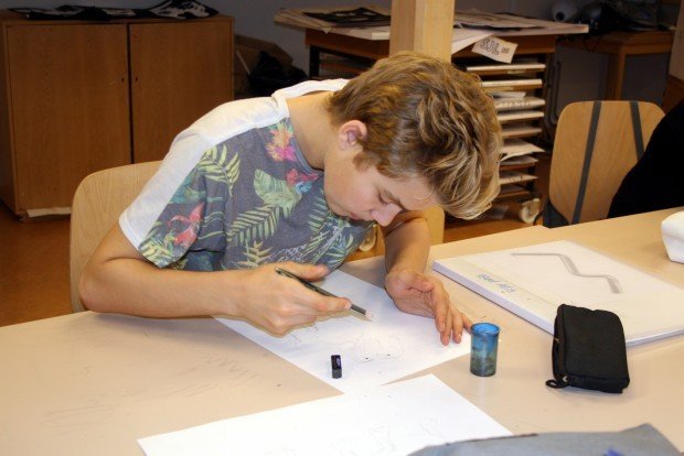 Önnum kafinn nemandi á listnámsbraut í teikningu.