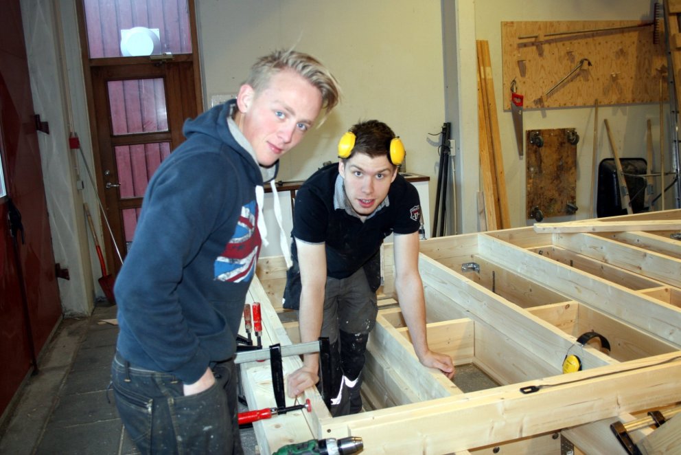 Glaðbeittir nemar að smíða sumarbústað.