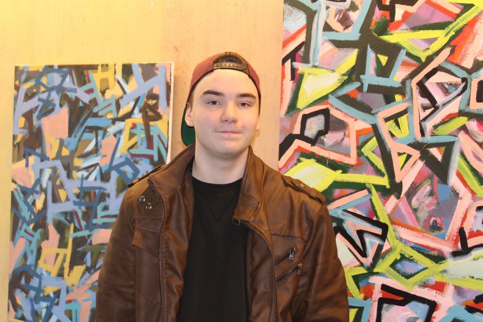 Ísak Lindi Aðalgeirsson við abstraktverkin sín.