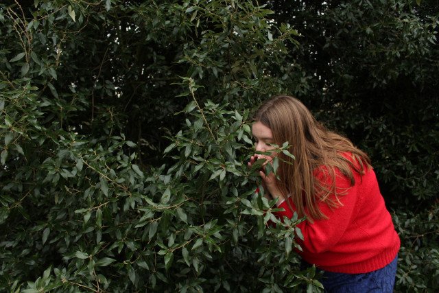 Agnes Ársæls andar að sér ilmi trjálaufanna.