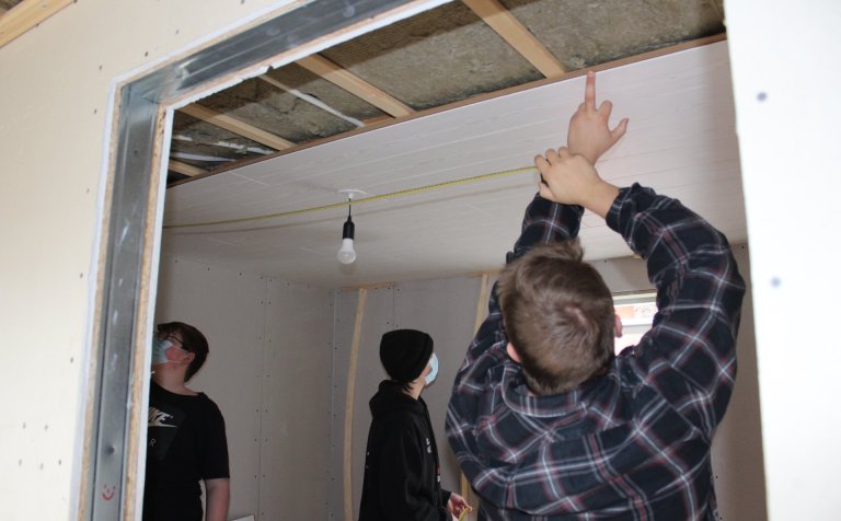 Unnið að því að festa loftaþiljur.