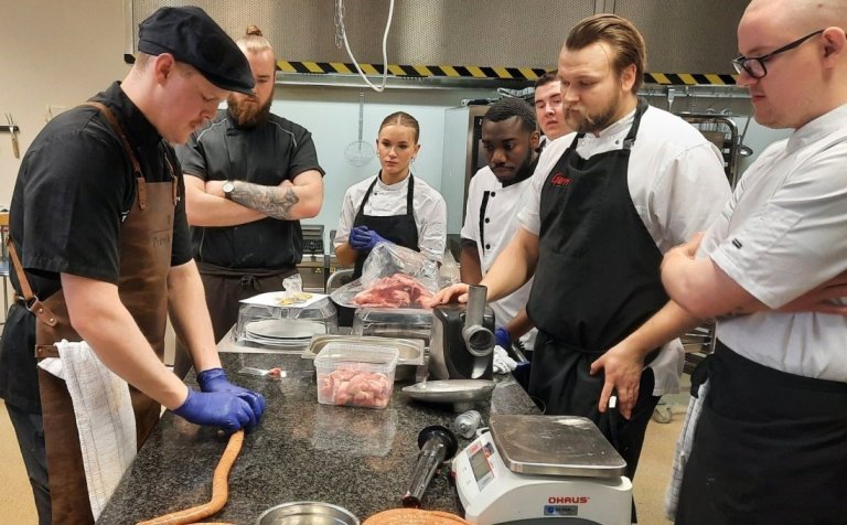 Rúnar Ingi Guðjónsson kjötiðnaðarmaður leiðbeinir nemendum í pylsugerðinni.