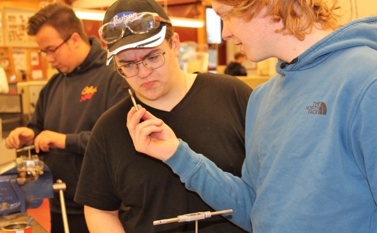 Nemendur í bifvélavirkjun bera saman bækur sínar.