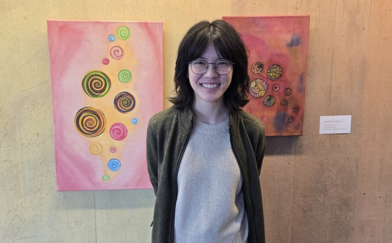 Aðalheiður Jóna Kolbeins Liljudóttir við vatnslitaverkin sín tvö sem hún kallar Hring eftir hring.