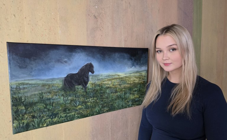 Diljá Ísfold Sigurpálsdóttir við akrílmynd sína af stóðhestinum Erni.