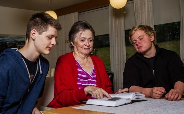 Nemendur VMA glugga í bók með íbúum á Hlíð.