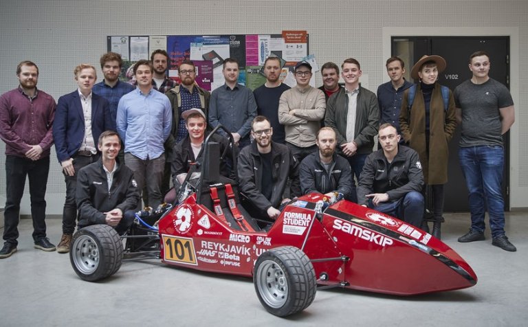 Arnór við bílinn, krjúpandi í miðju.