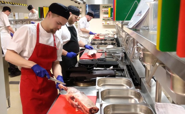 Nemendur spreyta sig á úrbeiningu lambalæra.