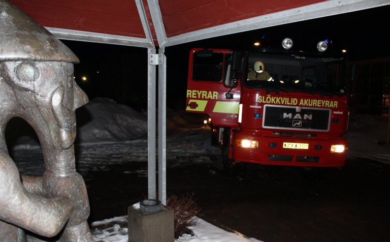 Bíll Slökkviliðs Akureyrar við austurinnganginn.