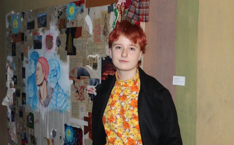 Loki Hilmarsson við mynd sína í húsakynnum VMA - á vegg gegnt austurinngangi skólans. Verkið er stór…