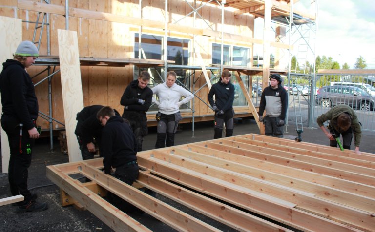 Nemendur byggingadeildar smíða grind undir húsið.