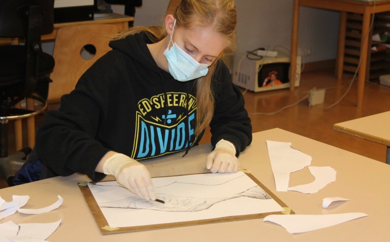 Unnið að listsköpun með kolum.