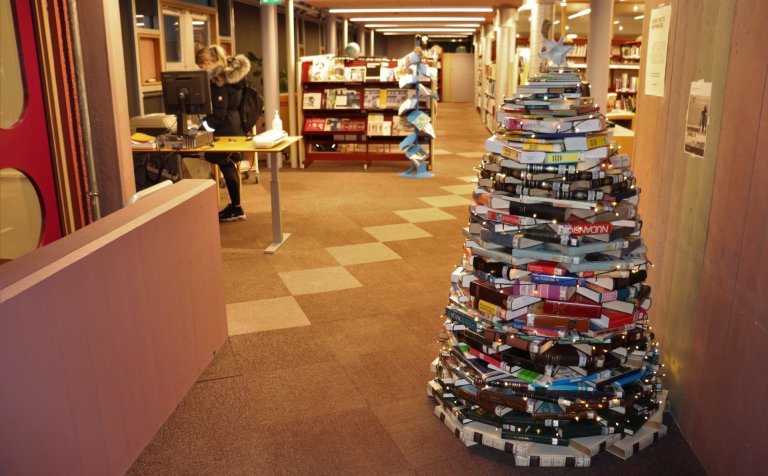 Bókajólatré í stofu (bókasafni) stendur.