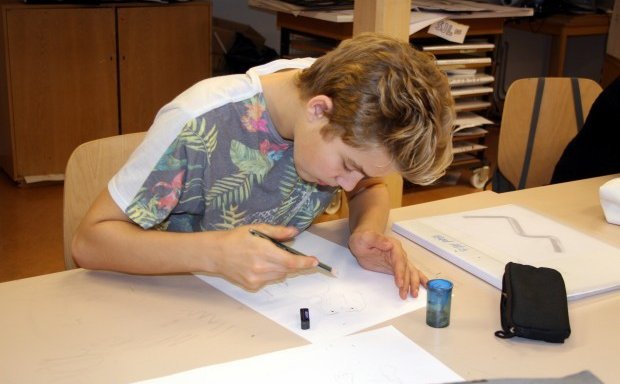 Önnum kafinn nemandi á listnámsbraut í teikningu.