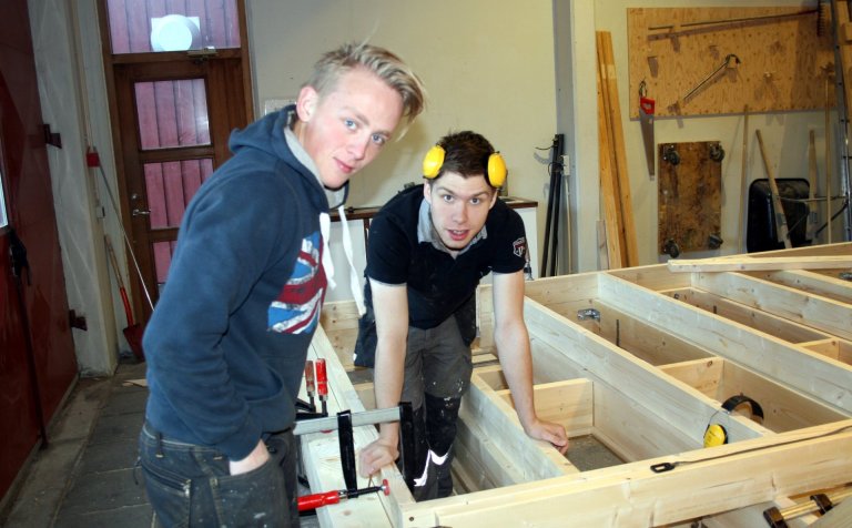 Glaðbeittir nemar að smíða sumarbústað.