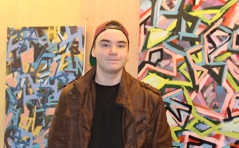 Ísak Lindi Aðalgeirsson við abstraktverkin sín.