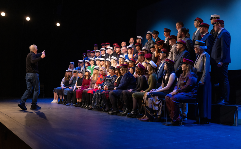 Páll A. Pálsson ljósmyndari leggur línur með uppstillingu fyrir hópmyndatöku á sviðinu í Hofi eftir …